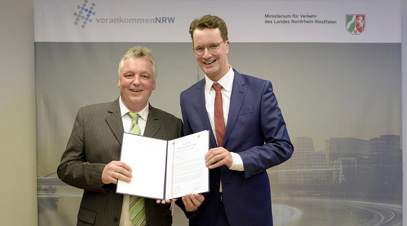 Andreas Brodowski von der Stadt Paderborn (Sachgebietsleitung Geoinformationsservice) zeigt mit NRW Ministerpräsident Hendrik Wüst ein Dokument in die Kamera.