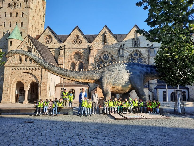 Auf dem Foto kann man sehen, wie die Schüler*innen vor dem riesigen Langhals stehen!