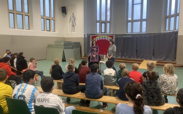 Frau Haake und Frau Haese reden miteinander. Im Vordergrund sieht man die Hinterköpfe der Kinder.