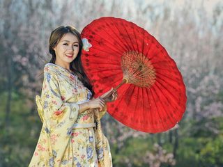 Frau im Komono mit Schirm