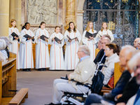 Mädchenchor singt mit offenen Gesangbüchern in einer Kirche