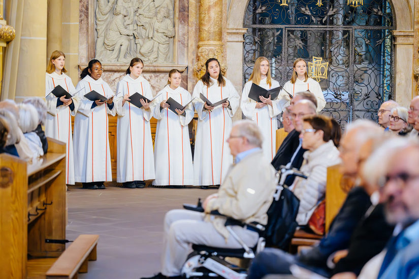 Mädchenchor singt mit offenen Gesangbüchern in einer Kirche